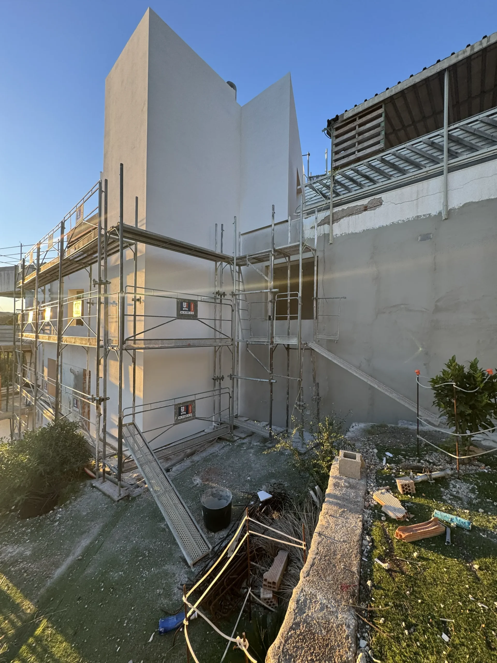 Fachada SATE con una zona acabada y otra todavía en proceso
